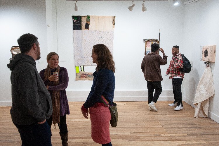 People view art in a gallery during a ceremonial opening of a new  arts hub and exhibit space in the Kress Building on Seventh Avenue in Ybor City.