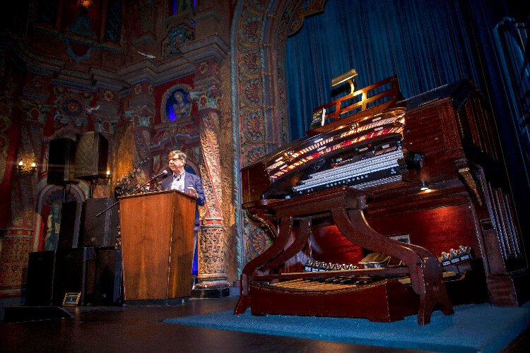 Author and MC Paul Wilborn addresses the crowd at the screening of  “La Gaceta The Documentary: 100 Years and 3 Generations Behind America's Only Tri-lingual Newspaper” after fulfilling his dream of playing the Tampa Theatre Wurlitzer pipe organ.