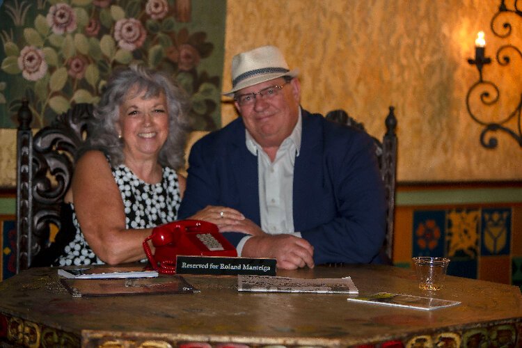 Documentary filmmaker Lynn Dingerfelder sits with La Gaceta third generation publisher, Patrick Manteiga, at the iconic table his late father, Roland, used to hold court at  daily at Ybor City's La Tropicana Restaurant.