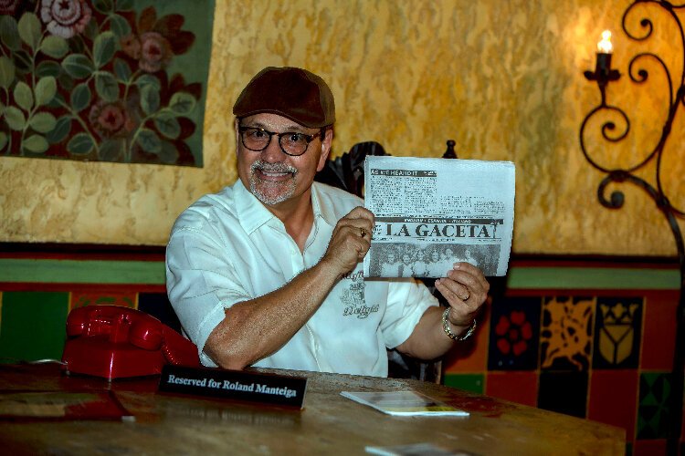 Tampa Natives Show host Mario Nunez sits at the iconic reserved table (with his red phone) that the late La Gaceta publisher Roland Manteiga help court at daily inside Ybor City's La Tropicana Restaurant.