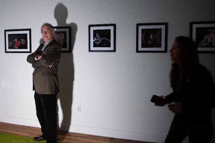 Artist and photographer Michael Sheehan stands next to his work in gallery space at the Ybor Kress Building.