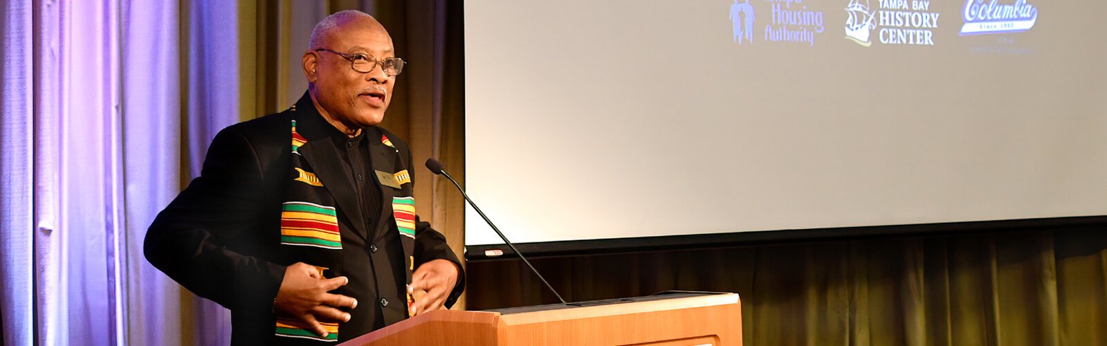 TBHC Historian and Curator of Black History Fred Hearns points out the Kente stole marking this special occasion. A woven fabric from Ghana, West Africa, Kente cloth was traditionally worn by royalty. 