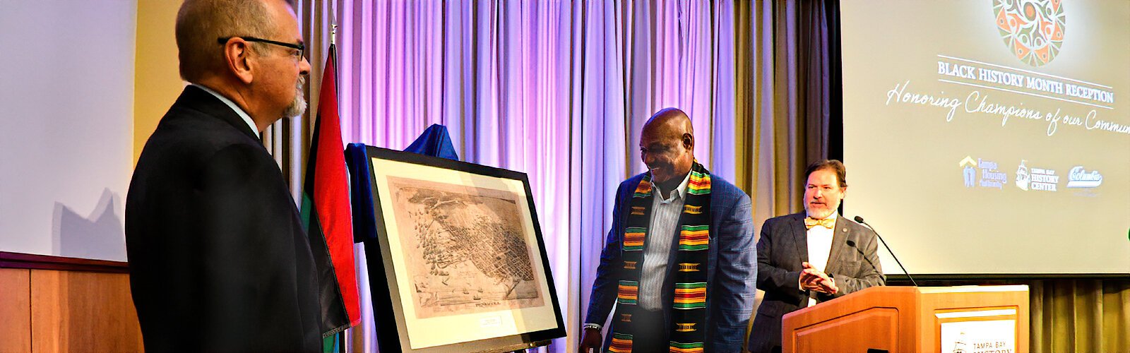TBHC President and CEO C. J. Roberts and TBHC Historian and Touchton Map Library Director Rodney Kite-Powell present Derrick Brooks with a framed historical map of his native Pensacola.