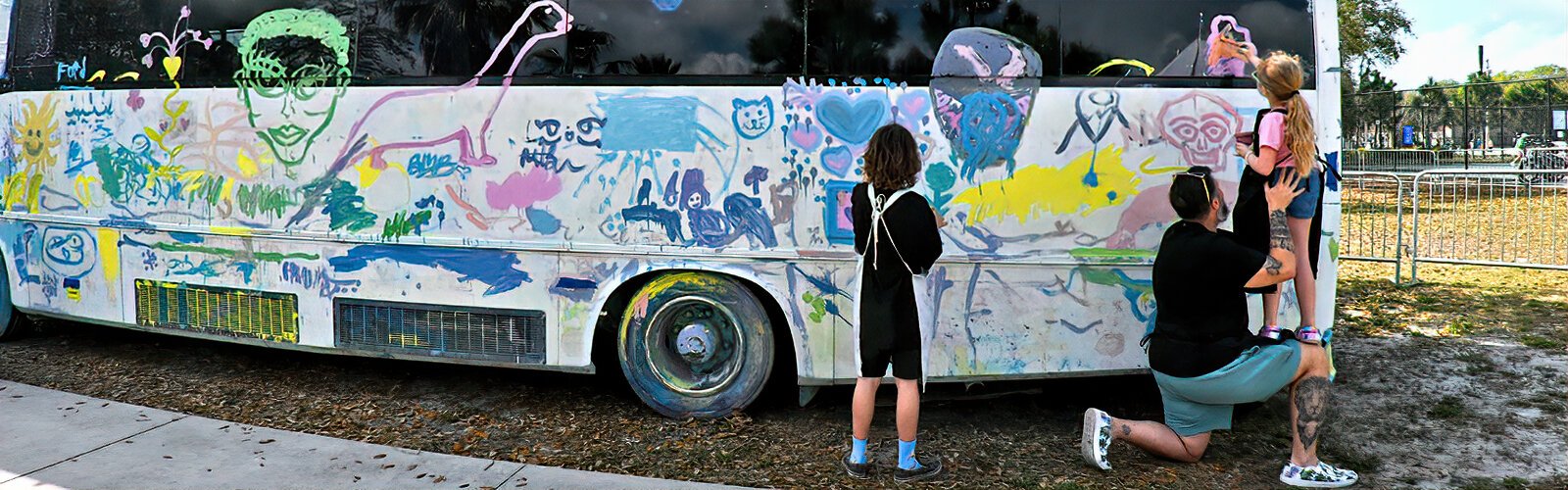 Will Shields provides his 7-year-old daughter Rylie with a higher vantage point so that she can add her touch to the NOMAD Art Bus. The interactive experience is made possible by NOMADstudio, whose mission is “art for ALL."