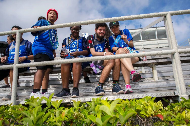 Omaries Rivera Perez, seated with her Specially Fit Foundation teammates, shows her first-place ribbon in the shot put at the March 25th ​Special Olympics Hillsborough-Pinellas Summer Games​ at Tampa's Jesuit High School.