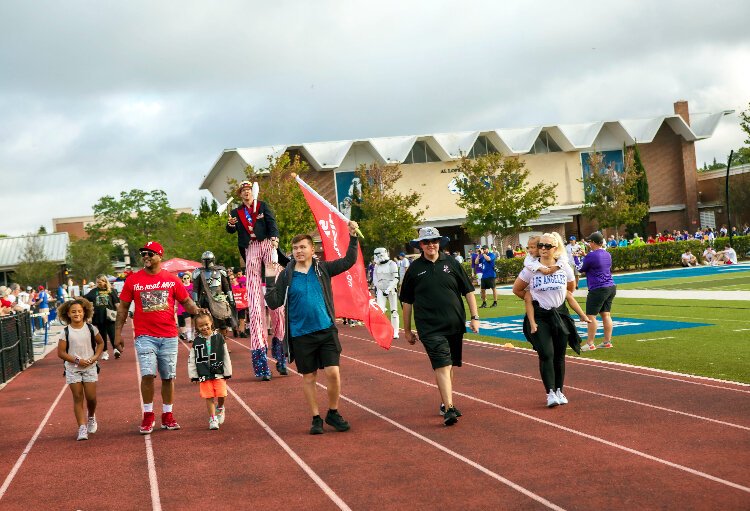 Former Tampa Bay Buccaneer defensive back Dwight Smith served as grand marshal of the Parade of Champions and walked with his family alongside Jacob Sare, an athletic leader with Pinellas County who carried the flag.