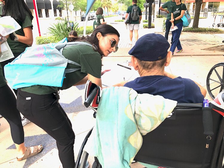 USF Morsani College of Medicine student Doniya Milani, street run director for Tampa Bay Street Medicine, asks a homeless man about his health.