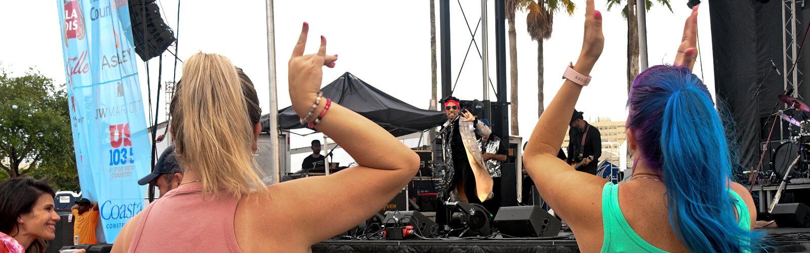Prince tribute artist Sir Jac gestures “I love you” in American sign language to his fans at the Tampa Riverfest live concert on Saturday evening.