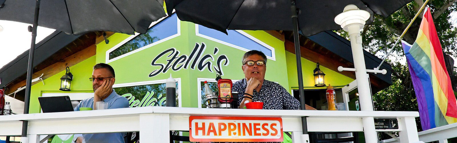 Seated by one of Gary King’s "HAPPINESS" signs, St Pete photographer J. R. enjoys relaxing moments on the open patio of Stella’s restaurant in Gulfport.