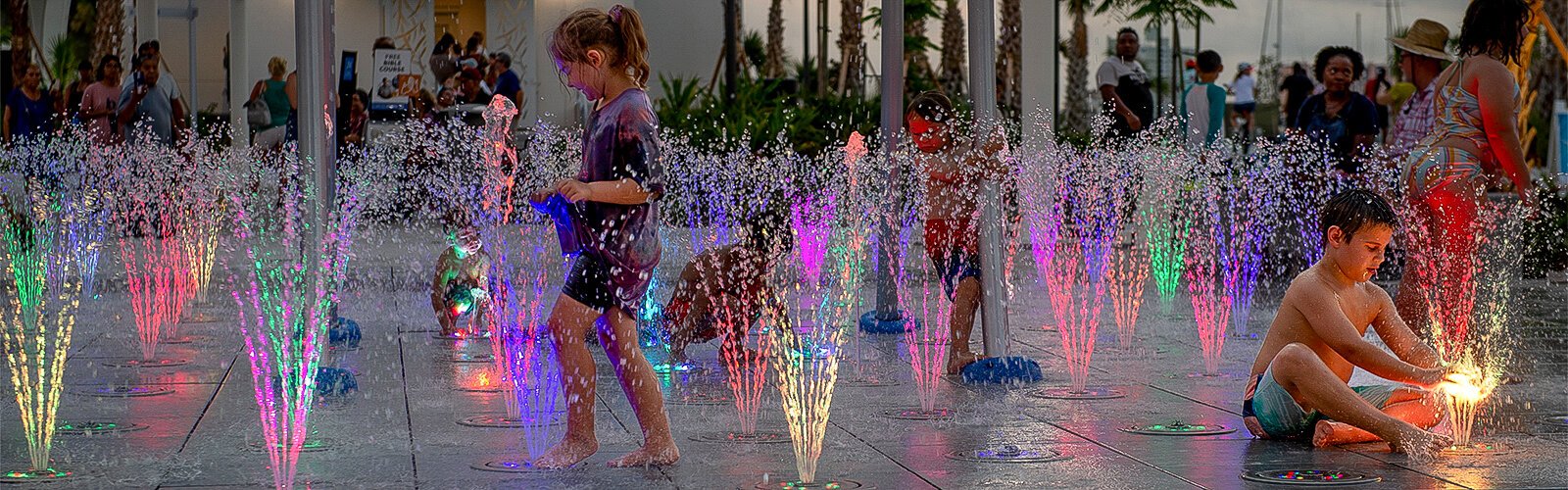 Children enjoy the cool and colorful fountains of the splash pad during the grand opening of the rebuilt Coachman Park in Clearwater.