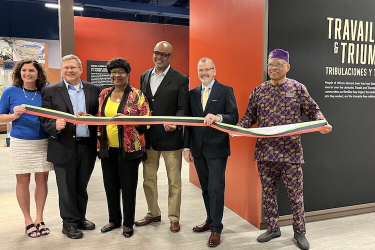 Dignitaries, including Curator of Black History Fred Hearns (right), helped cut the ribbon for Travails and Triumphs at the Tampa Bay History Center.