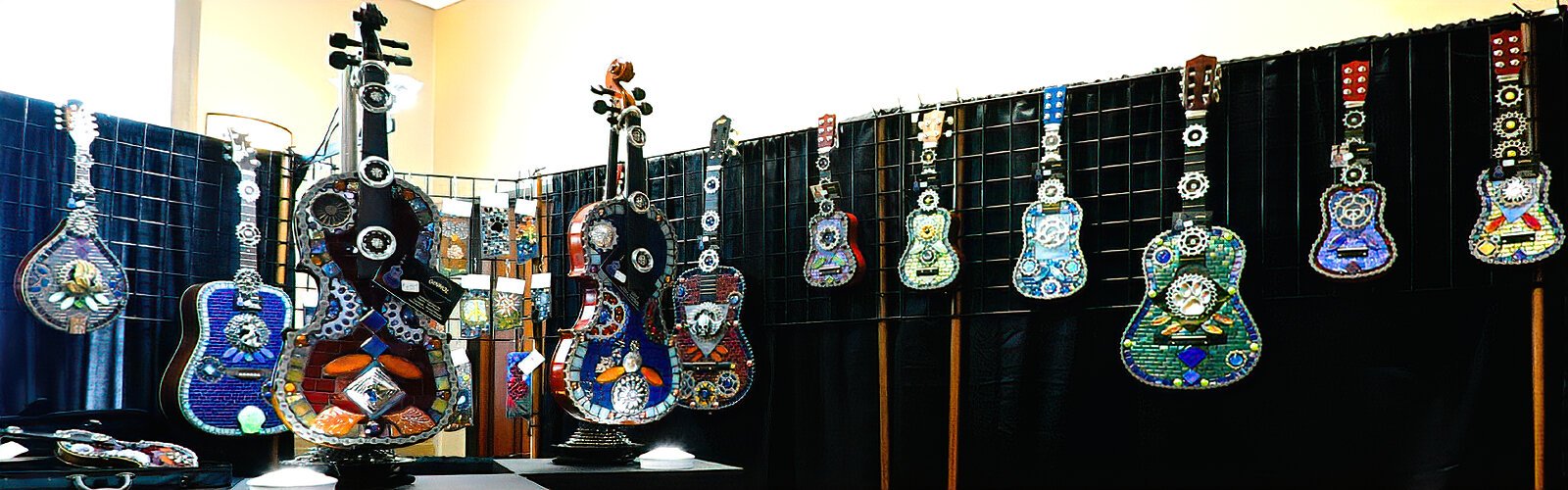 Ginhol Mosaics showcases repurposed guitars, mandolins and violins embellished with vivid colorful stained glass, salvaged bicycle parts and found metal objects by Safety Harbor mosaic artist Holly Apperson.