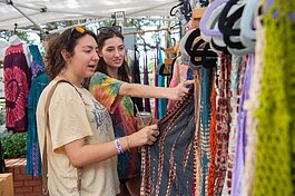 Camila Castaneda and Sage Hall, both of Orlando, browse clothes at the Ybor City Saturday Market.