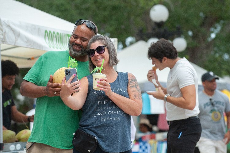 Matthew Washington and Tia Romano, both from Panama City, take a ‘selfie’ after buying a cool beverage at the Ybor City Saturday Market.