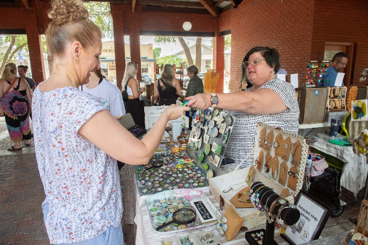 Longtime vendor Susan Hall, of ReUsin' By Susan, makes a sale at the Ybor City Saturday Market