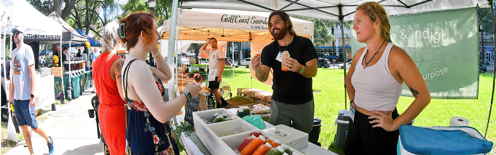 Michael and Sarah, owners of Sage & Indigo Juice Co. in Fort Myers, offer a sample of their cold-pressed juices to an undecided customer with the hope to spread healing and health with every bottle.