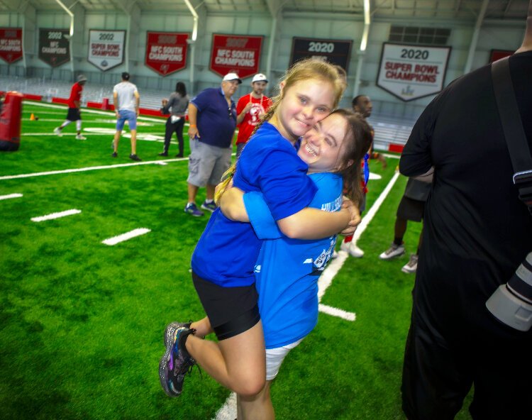 Mary Frances Smith, reigning Florida Special Olympics Athlete of the Year, lifts up her good friend and fellow tennis aficionado, Aviella Braun, as the Tampa Bay Bucs welcomed Special Olympics Florida athletes to training camp.