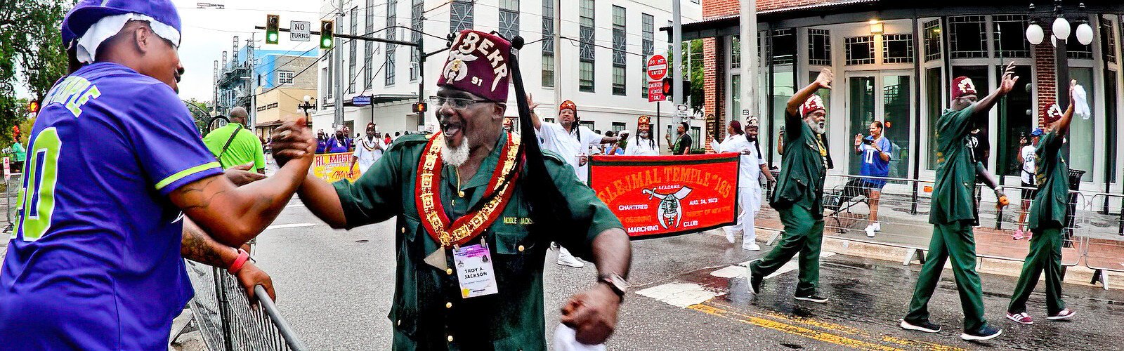 Troy A. Jackson, a member of the Abu Bekr Temple No. 91, Oasis of Brooklyn, Desert of New York, recognizes and greets a fellow member of the shrinedom watching the parade.