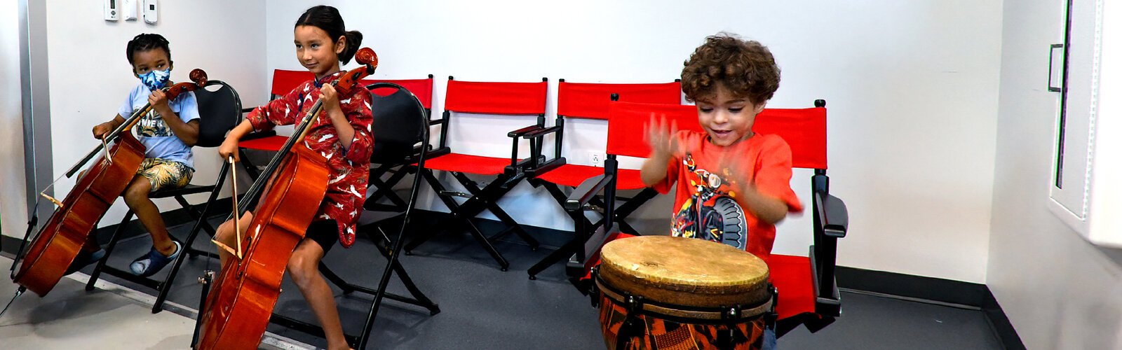 Xander, age 6, and Sofia, 6, try out cellos while Nicholas, 5, has fun at the drum at The Florida Orchestra’s “Petting Zoo," which gives kids the experience of playing a musical instrument.