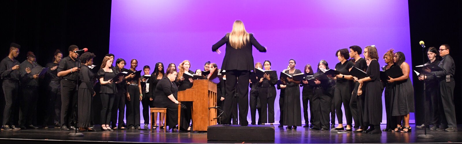 The Hillsborough Community College Music Department performs on stage in the theater of the New Tampa Performing Arts Center with an impressive cast of chorists and musicians.