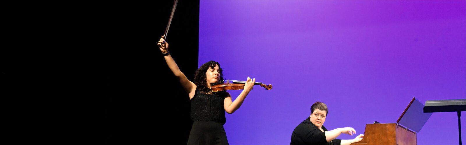 Performing with the Hillsborough Community College Music Department, violinist Laura Martin ends her Rhapsody with flair as accompanying pianist Amy Stefanov looks on.