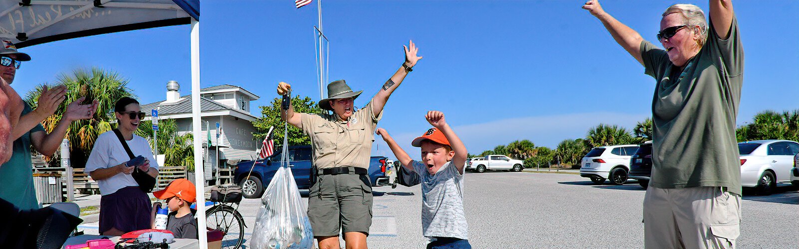 Applauded by his parents, six-year-old Charlie jumps in excitement as Honeymoon Island park ranger Beth Reynolds announces the weight of the trash collected by him and his family.