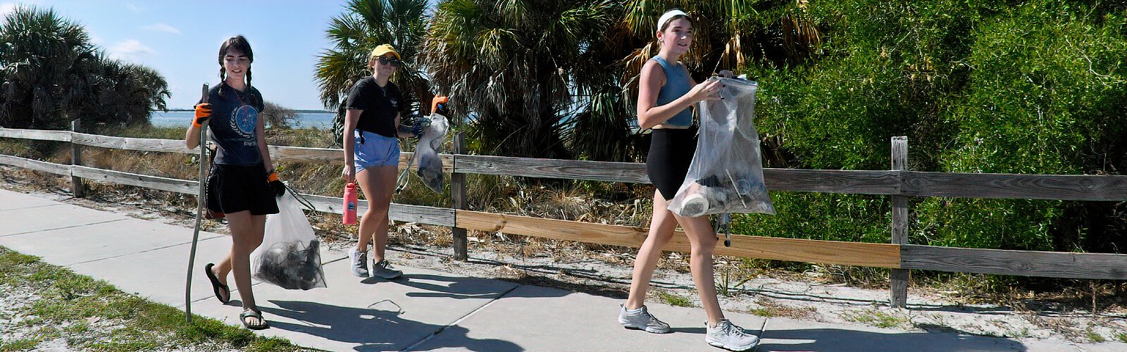 Encouraged by the International Coastal Cleanup campaign to volunteer and make a difference in their local communities, three young women return from the beach cleanup with bags of litter to be weighed.