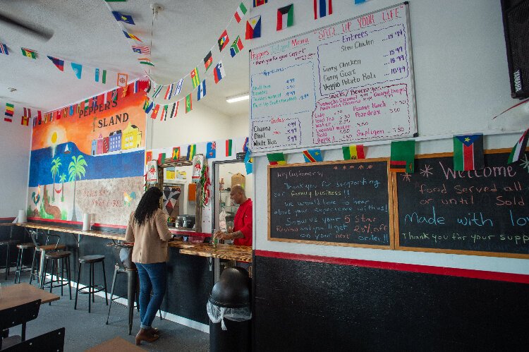 Rodney Dhanraj takes an order at his new Trinidadian restaurant in Ybor City, Pepper's Island.