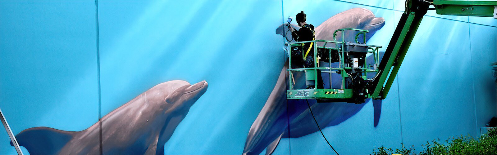 Artist Sonny “Sundancer” Behan, acclaimed for his large-scale wildlife murals, brings dolphins to life at the Art in the Park celebration in Clearwater's Coachman Park.