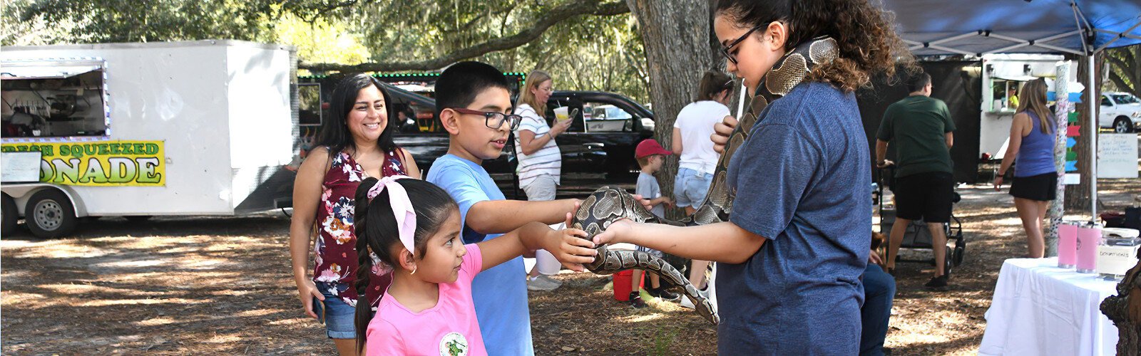 Volunteering with Roos & Coos Farm, Sara, 13, encourages young visitors to pet Bagheera, a mellow 18-year-old ball python, at the Wonders of Wildlife Festival at Edward Medard Conservation Park in Plant City.