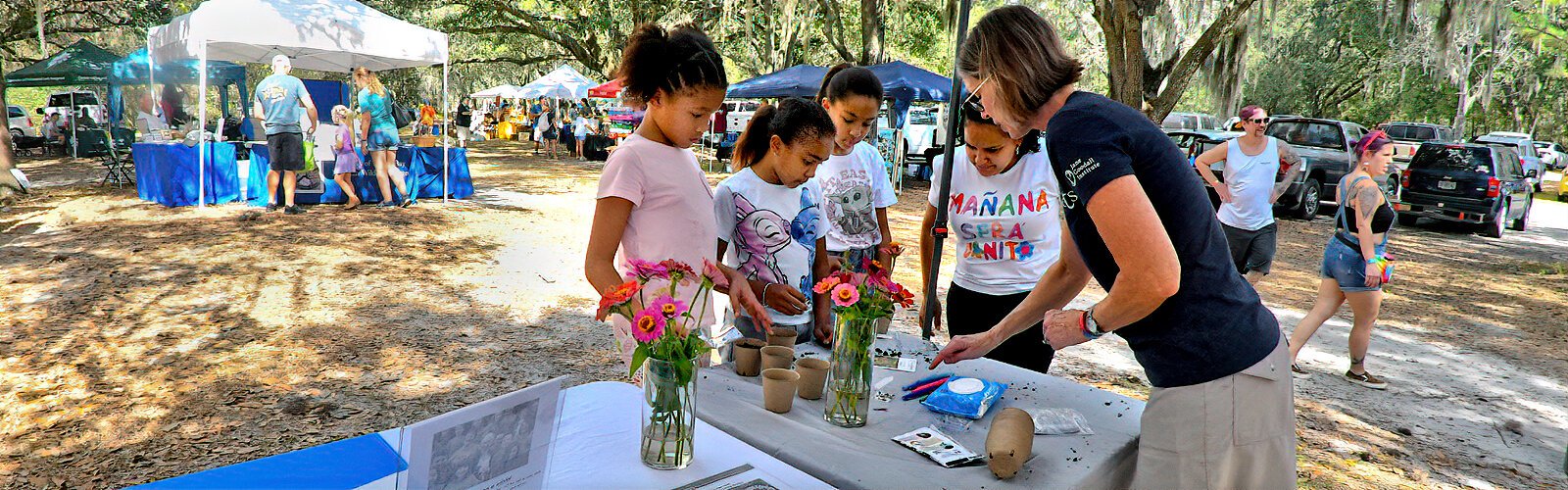 Bonnie Eaton, the Tampa Bay basecamp coordinator for the Jane Goodall Institute's Roots & Shoots youth program, explains how to collect seeds from zinnias and plant them in a small pot to take home. 
