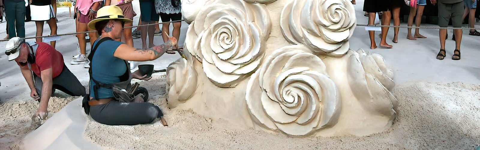 Mélineige Beauregard, of Montreal, Canada, puts the finishing touches to her sand creation “Take Time to Smell the Roses” at the Sanding Ovations sand sculpting competition event.