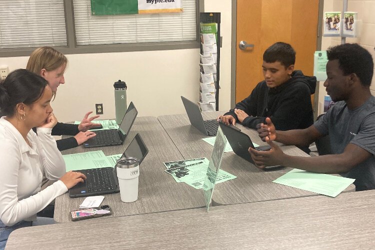 Dunedin High School seniors Kate Abrams, Campbell Hudson, Joel Suaz and  Emmanuel Chanda work together in the school's College and Career Center office.