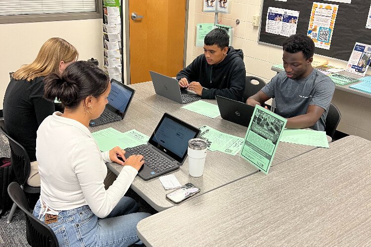 Dunedin High School seniors Kate Abrams, Campbell Hudson, Joel Suaz and  Emmanuel Chanda work together in the school's College and Career Center office.