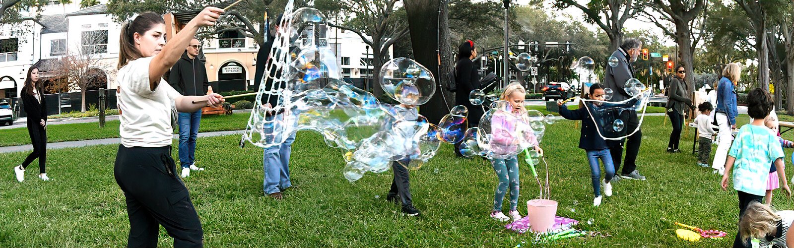 Children imitate Abby from the Sensory Studio in making giant soap bubbles. First Night is a free event open to all, thanks to sponsors Hines and the Tampa Bay Rays.