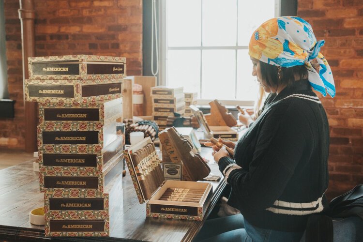 A J.C. Newman Cigar Company worker fills a box of premium cigars. "The American" is one of the signature cigars hand-rolled at El Reloj.