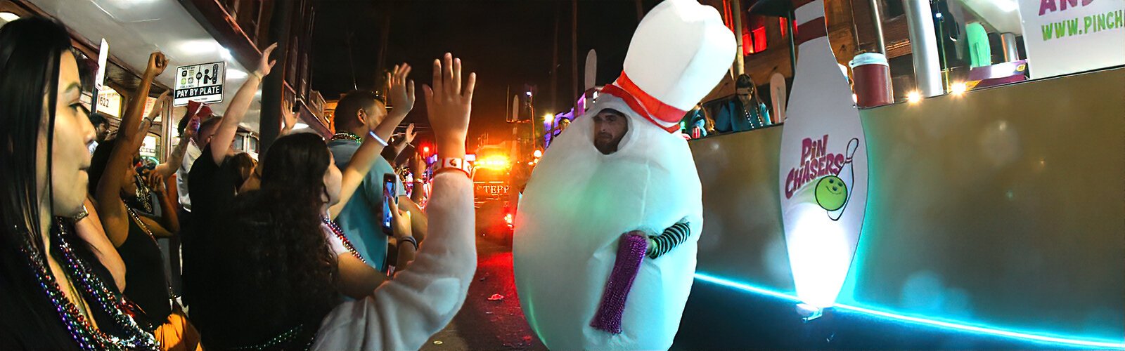 Wearing a bowling pin costume, a member of the Pin Chasers entertains spectators along the Knight Parade route on Seventh Avenue in Ybor.