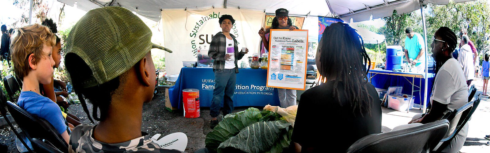 With the help of a young volunteer from the audience, Renee of the UF/IFAS Family Nutrition Program explains how many spoons of sugar soda drinks contain and how to make healthier choices.