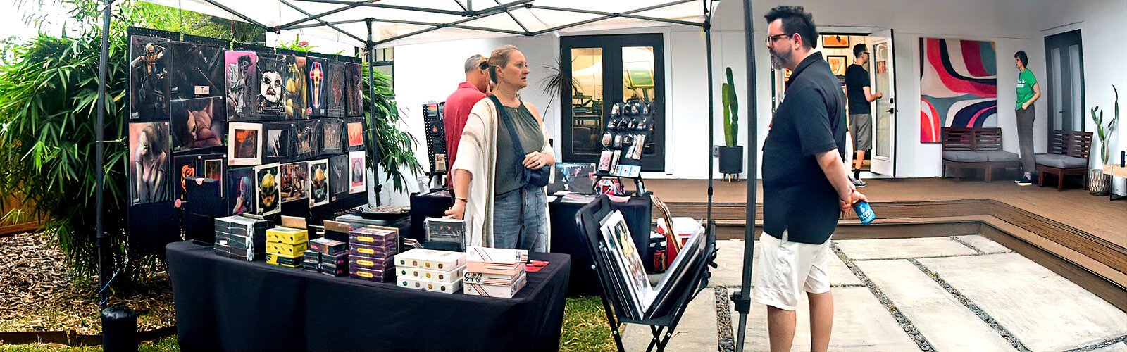 Digital artist Nick Ribera chats with visitors as they explore his booth, which is set up in the garden shared with screen printer Mike Toh.