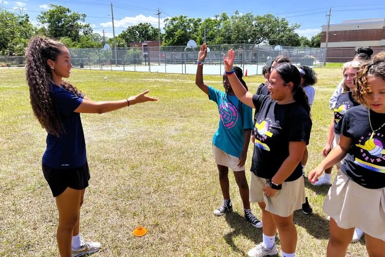 Tampa Bay Sun player Domi Richardson asks Ferrell Girls Preparatory Academy students a question when Sun players and the Rise Up Soccer Club visit the school for skills drills and a pep rally