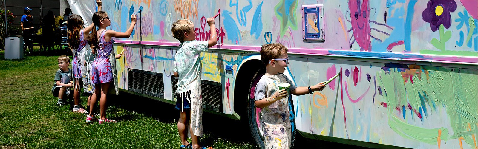  Children paint NOMADstudio’s NOMAD Art Bus during MFA St. Pete’s Painting in the Park 2025.