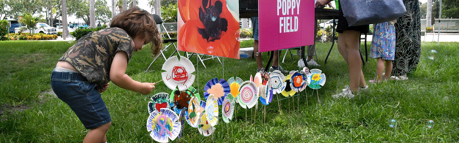  Finn, 3, places his decorated paper plate in the poppy field inspired by Georgia O’Keeffe, a creative activity enjoyed by several budding artists.