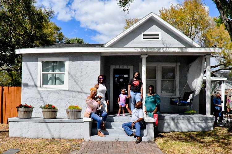  Harold “Tony” Doby Jr, great-grandson of Ernest Doby, poses with members of his family on the porch of a former Doby family house on Azeele Street. Built circa 1912, this was once the home of Richard C. Doby’s son Ernest.