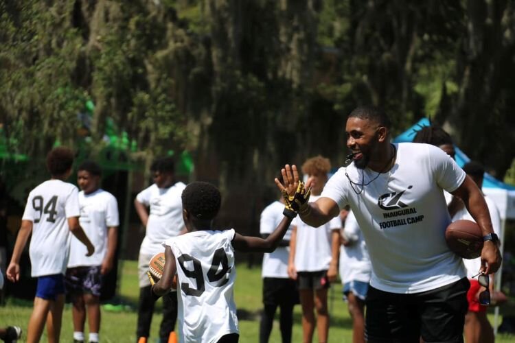 The University Area CDC's inaugural Get Moving! youth football camp in July 2024 featured Tampa Bay Bucs players Calijah Kancey, Tykee Smith, and Rachaad White